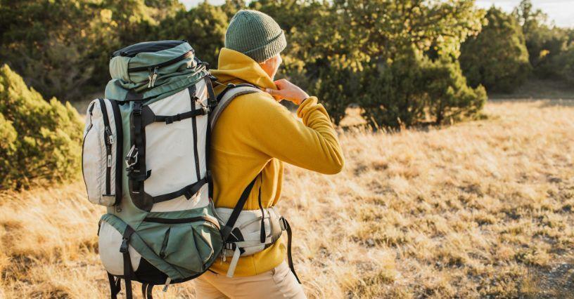 Muž s batohem na zádech prozkoumává přírodu